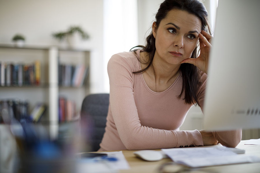 Worried businesswoman looking at computer screen Concerned taxpayer