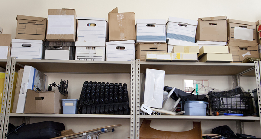 Bankers boxes in an office A stack of office supplies piled high in a storage room includes bankers boxes